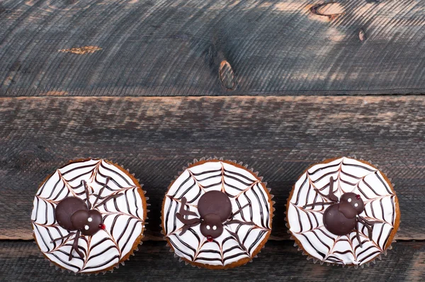 Lustige Kürbis-Cupcakes mit Spinnen und Totenkopf für die Halloween-Party. Halloween-Hintergrund — Stockfoto