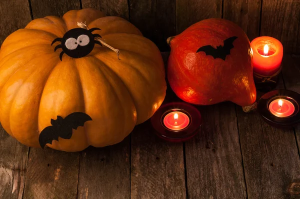 Kürbisse, Kerzen und lustige handgefertigte Spinnen und Fledermäuse für die Halloween-Party — Stockfoto