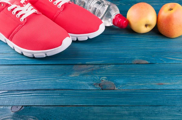 Mode de vie sain. Chaussures de sport, bouteille d'eau et pommes sur fond en bois. Concept vie saine et sportive — Photo