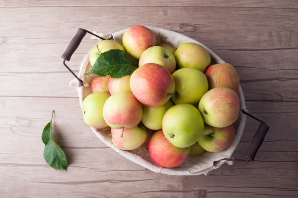 Fresh harvesting apples in basket on wooden table. Healthy food — Stock Photo, Image