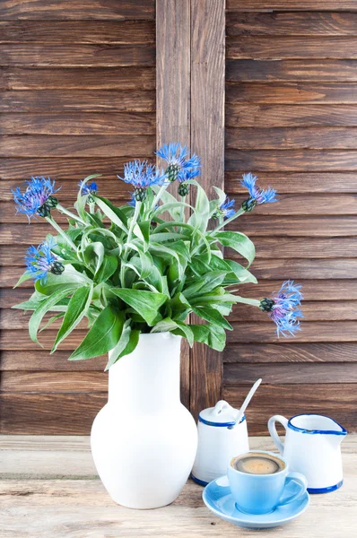 咖啡杯和矢车菊木背景与副本空间上的花束。在厨房里喝咖啡休息时间 — 图库照片