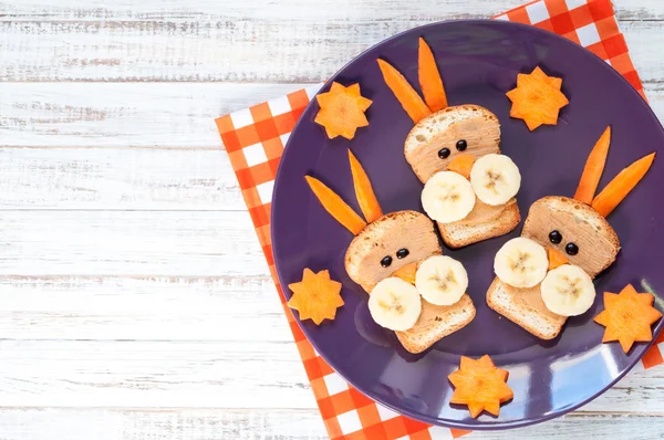 Children\'s breakfast - funny rabbit face sandwiches with peanut butter, banana and carrots