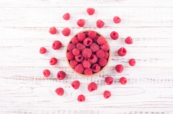 Raspberries in bowl on old wooden background. Compositions of summer berries. Flat lay — Stock Photo, Image