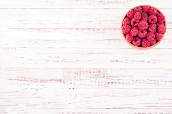 Raspberries in bowl on white wooden background. Compositions of summer berries — Stock Photo, Image