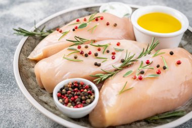 Gri beton masada baharatlı ve otlu tavuk filetosu. Tavuk beyazı et pişiriyorum.