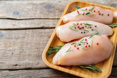 Kırsal ahşap arka planda çiğ tavuk göğsü pişirmek için malzemeli tavuk eti. Boşluğu kopyala