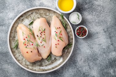 Gri masa üzerinde baharatlı sebzeli tavuk filetosu. Pişirmek için malzemeli tavuk eti. Boşluğu kopyala