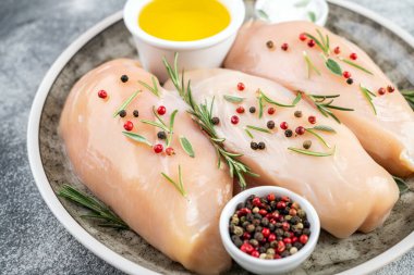 Gri masadaki baharatlı sebzeli tavuk filetosu. Pişirmek için malzemeli tavuk eti.