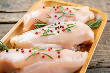 Kırsal ahşap masada sebzeli ve baharatlı tavuk filetosu. Tavuk beyazı et pişiriyorum.