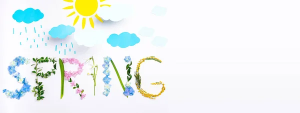 Creative concept made from flowers composition word spring on white. Paper craft handmade spring concept. Art floral, flowers background. Sunny, rain spring weather theme flat lay. Copy space