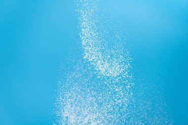 White powder explosion. White powder splash isolated on blue background. Flour sifting on a blue background. Explosive powder white clipart
