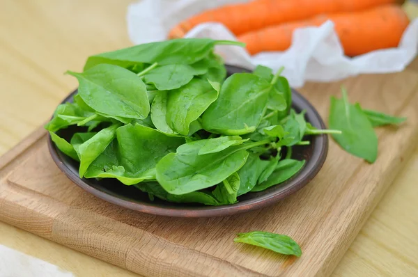 Spinaci e carote su una tavola di legno — Foto Stock