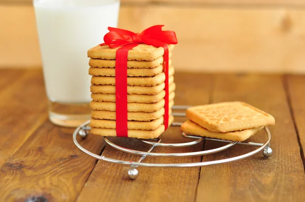 Biscotti con un nastro e un bicchiere di latte — Foto Stock