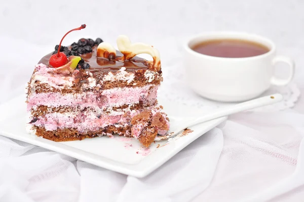 Pezzo di torta di bacche e una tazza di tè nero su uno sfondo bianco — Foto Stock