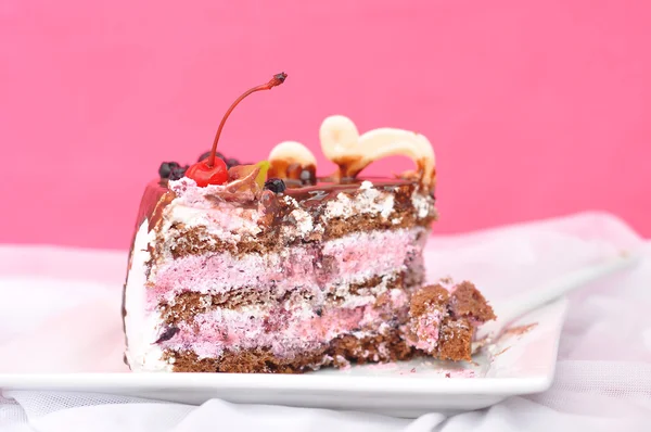 Pezzo di torta di bacche su uno sfondo bianco e rosa tessile — Foto Stock