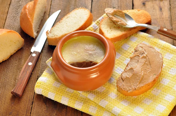 Pate dans une casserole en céramique et pain grillé sur une serviette. Cuillère et couteau — Photo