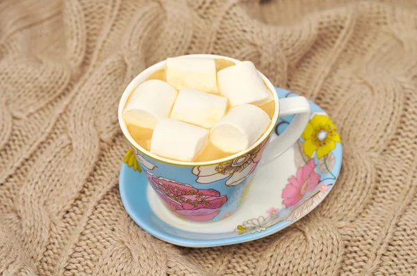 Marshmallow örme yün, İpek eşarp üzerinde mavi bir fincan kahveyle — Stok fotoğraf
