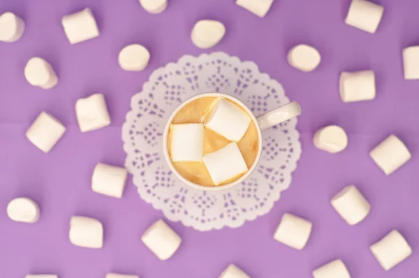 Caffè con marshmallow in una tazza viola su sfondo viola . — Foto Stock