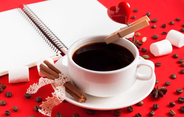 Una tazza di caffè con uno spillo e il cuore su sfondo rosso con ispico — Foto Stock