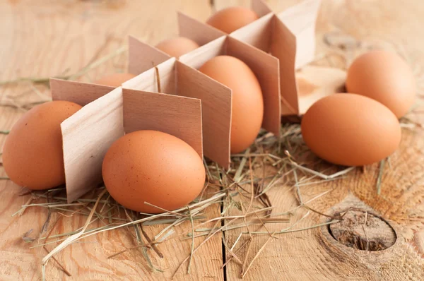 Eggs and hay on wooden background. Selective focus — Stock Photo, Image