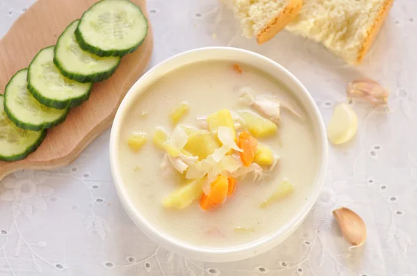 Cheese soup with chicken and vegetables in white bowl, cucumber — Stock Image Cheese soup with chicken and vegetables in white bowl, cucumber Royalty Free Stock Images