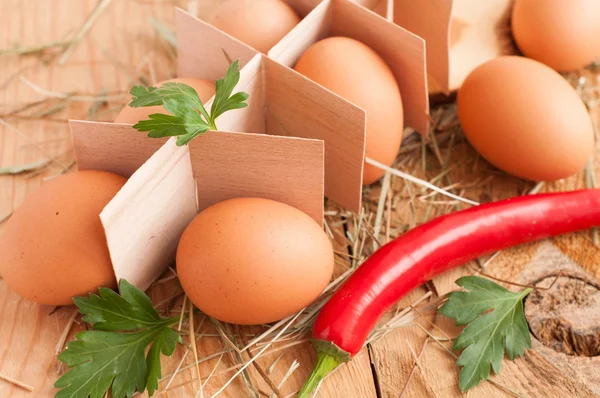 Fresh brown eggs, parsley and chili pepper — Stock Photo, Image