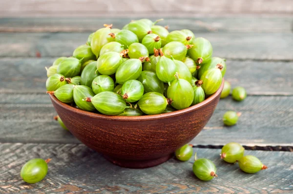 Frische grüne Stachelbeeren in einer Keramikschüssel. Stachelbeere aus nächster Nähe — Stockfoto