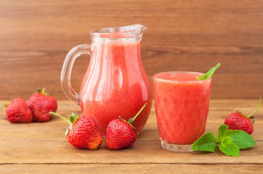 Strawberry smoothie with mint on a rustic wooden background. Hea