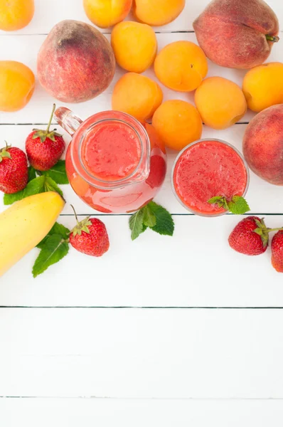 Healthy strawberry banana smoothie with mint in a glass and pitc — Stock Photo, Image