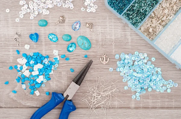 Crystals, pendants, charms, plier, glass hearts, box with beads — ストック写真