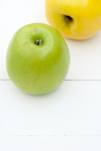 Green and yellow apples on a white wooden background closeup — Stock Photo, Image