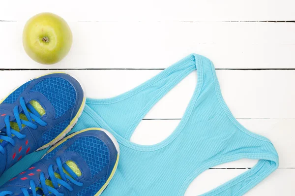 Zapatos deportivos antiguos, camisa y manzana sobre fondo blanco de madera — Foto de Stock