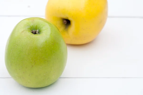 Grüne und gelbe Äpfel auf weißem Holzhintergrund in Nahaufnahme — Stockfoto