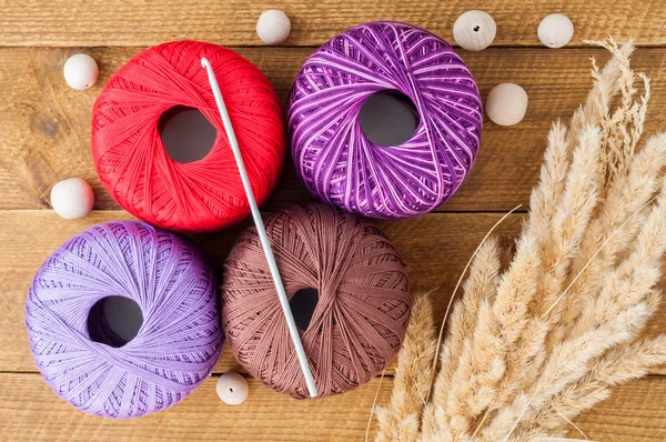 Yarn for knitting and wooden beads on a table. Accessories for k — Stock Photo, Image