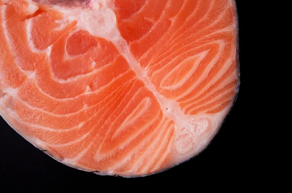 Closeup fresh raw salmon steak on a black background. — Stock Photo, Image