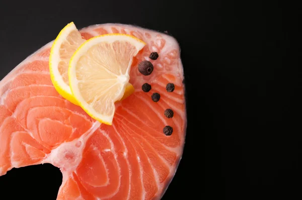 Fresh raw salmon steak red fish on a black background — Stock Photo, Image