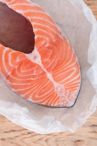 Zalm vissen biefstuk op houten achtergrond. Rode vis op papier — Stockfoto