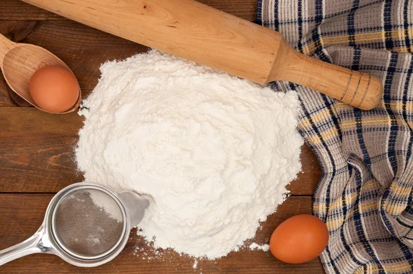 Ingredientes de panificação: ovo e farinha, peneira e rolo em madeira — Fotografia de Stock