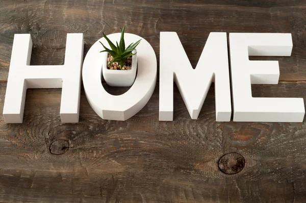 Letras de madera formando palabra HOME sobre fondo de madera . —  Fotos de Stock