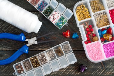 Box with beads, spool of thread, plier and glass hearts to creat clipart
