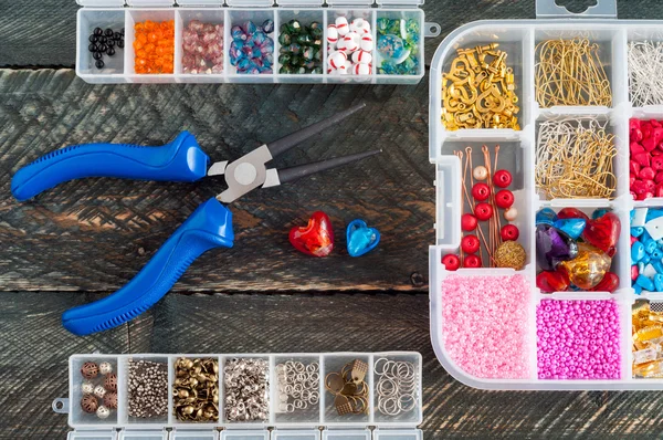 Boîte avec perles, bobine de fil, pinces et coeurs en verre à créer — Photo