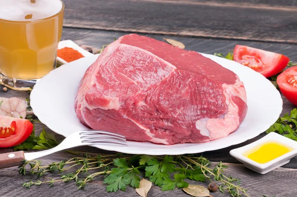 Carne crua com ervas, especiarias, legumes e cerveja em um copo em um — Fotografia de Stock