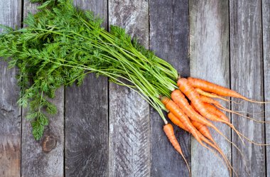 Fresh carrots on old wooden background clipart