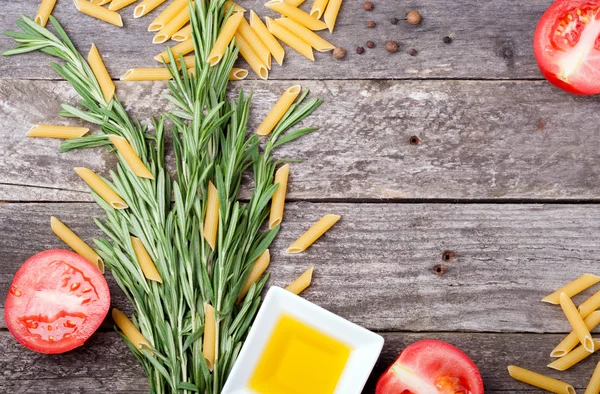 Penne pasta with rosemary, tomatoes, olive oil and pepper on a w — Stock Photo, Image