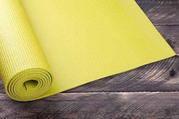 Yoga mat ahşap arka plan üzerinde. Ekipman yoga için. Kavram h