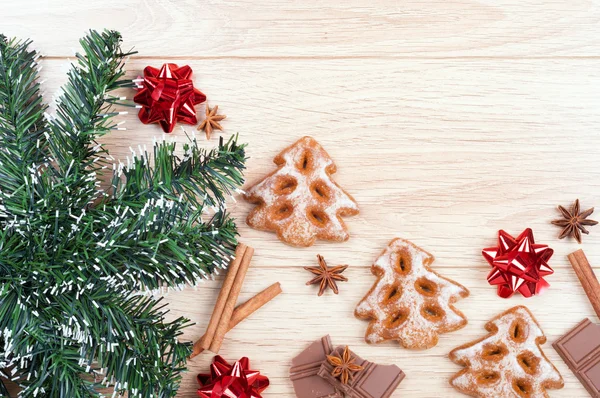 Biscoitos, chocolate, especiarias, arco de presente e abeto artificial em — Fotografia de Stock