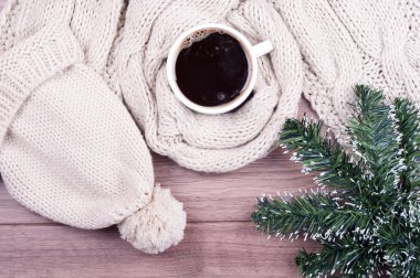 Coffee cup and handmade knitted wool scarf and hat. Winter woman