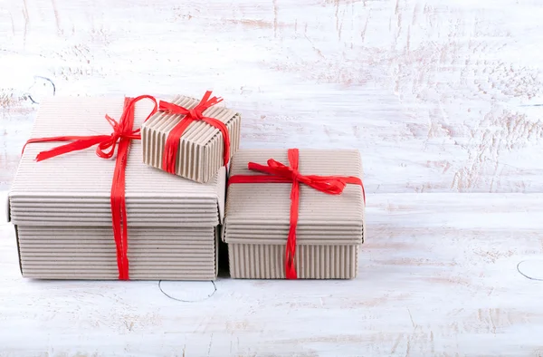 Різдвяні картонні коробки ручної роботи зі стрічкою рафії — стокове фото
