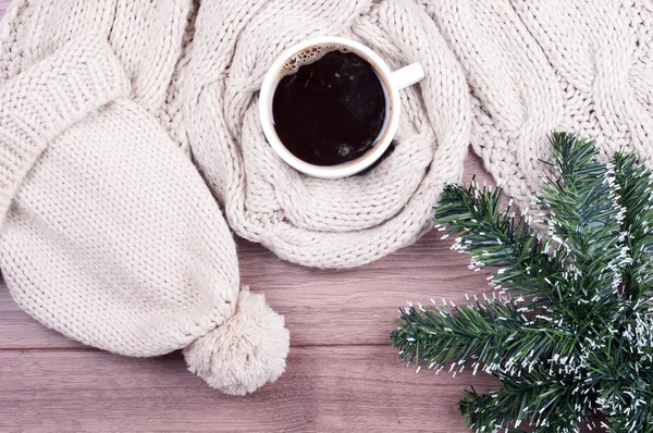 Coffee cup and handmade knitted wool scarf and hat. Winter woman