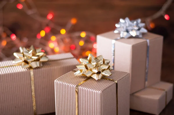 Gift boxes with golden bows on bokeh background — Stock Photo, Image